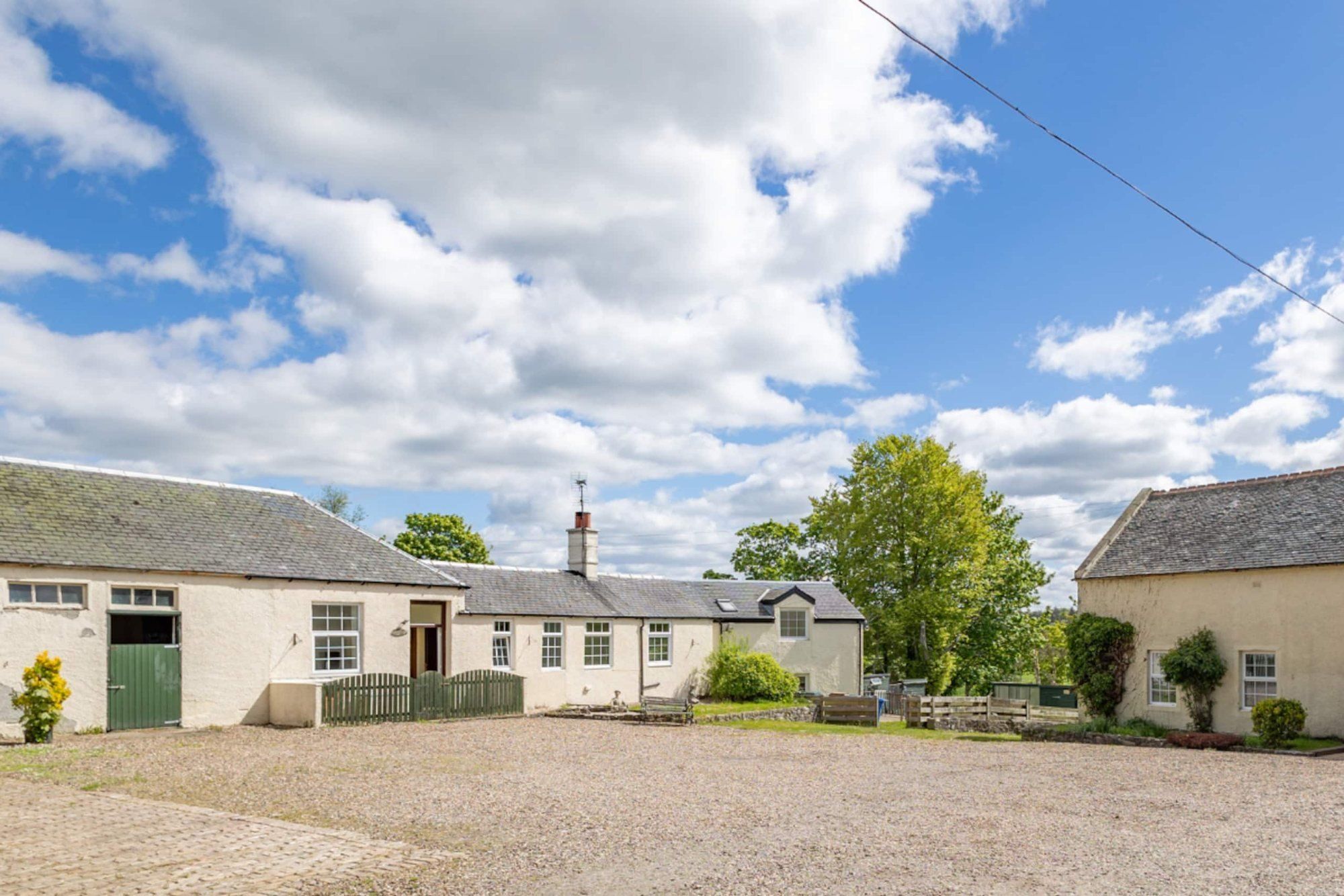 The whitewashed courtyard buildings at Corraith under a blue sky