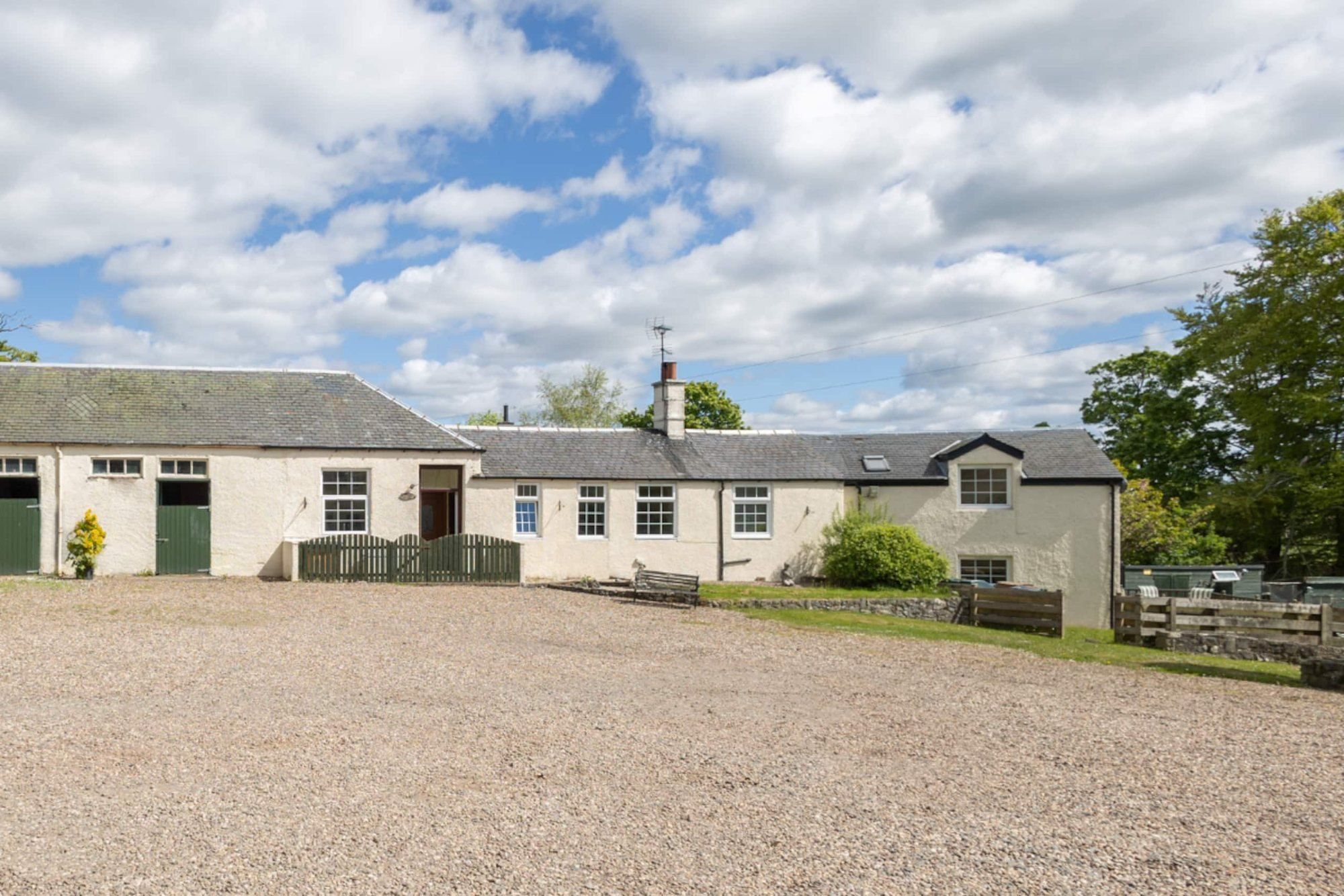 The gravel courtyard and whitewashed cottages at Corraith on a summer day