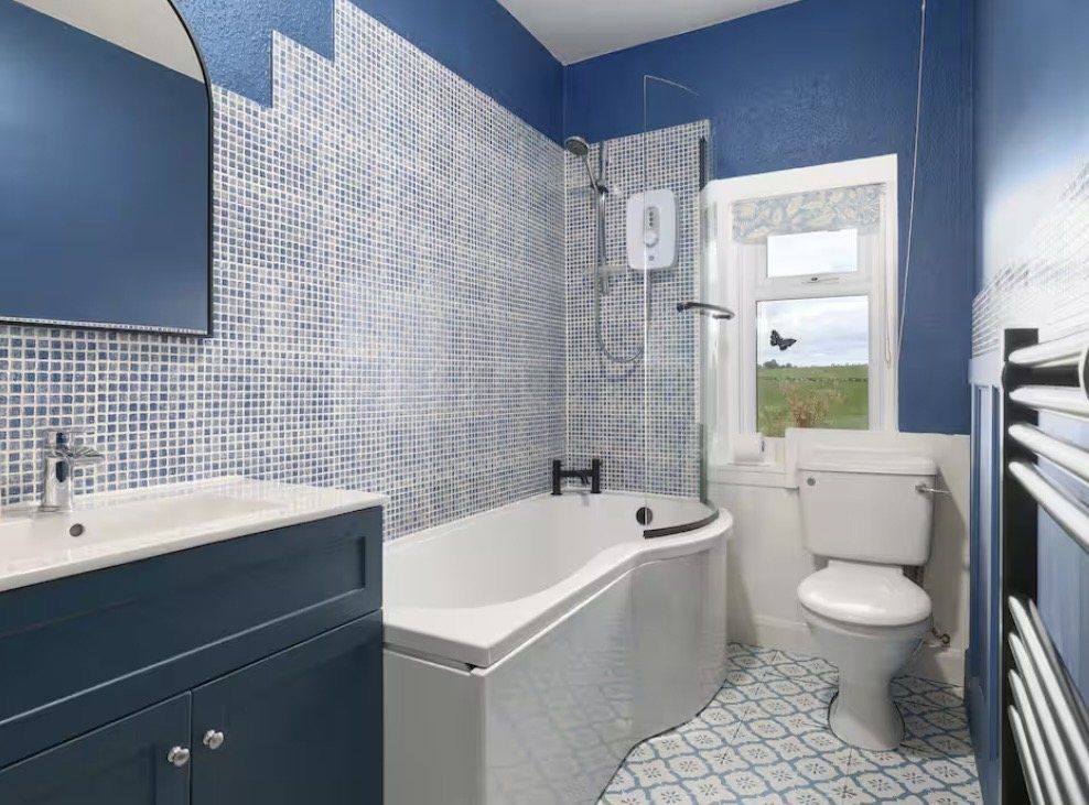 Navy and patterned-tile bathroom at Gardener's Cottage