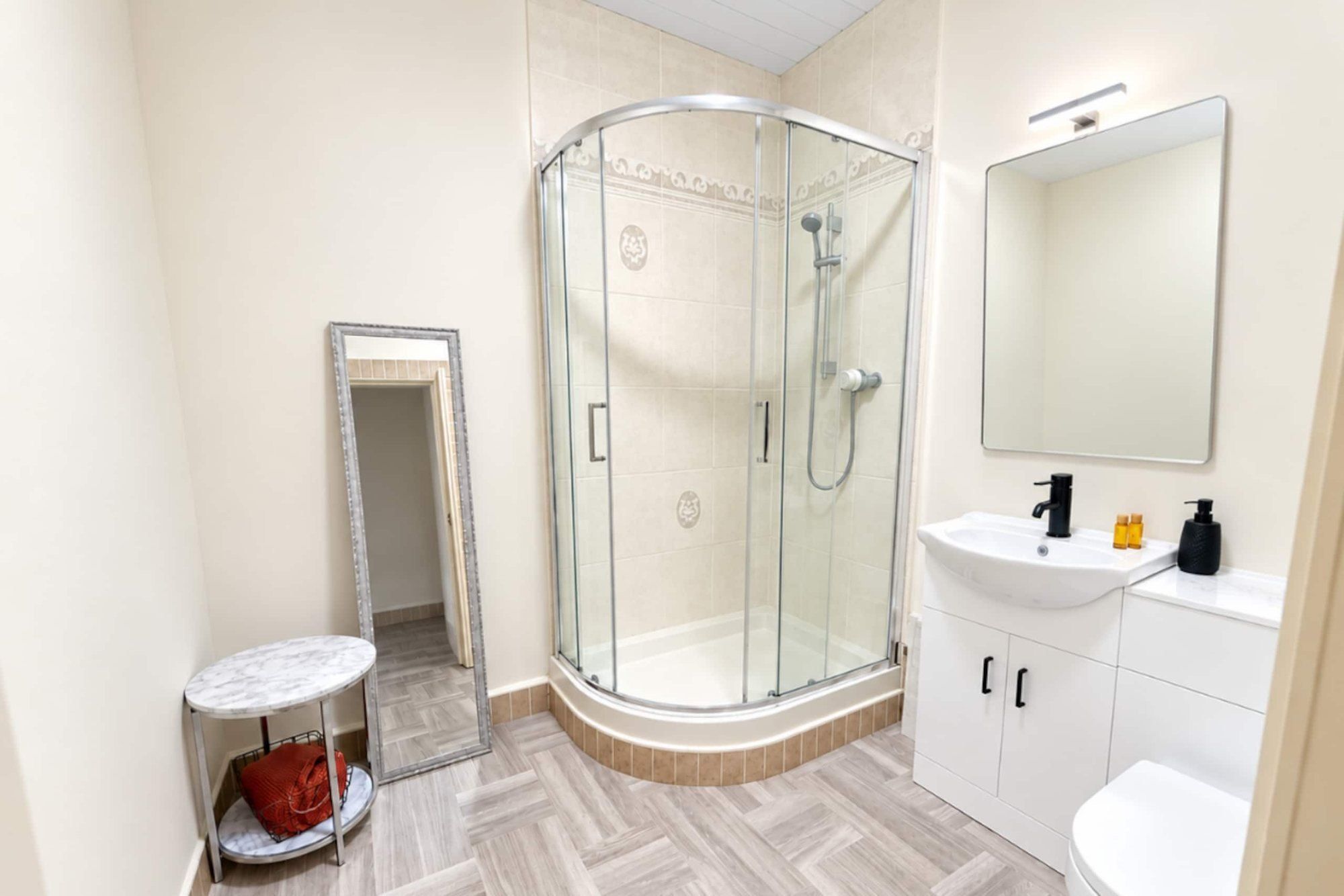 Shower room with a quadrant shower, vanity unit and long mirror
